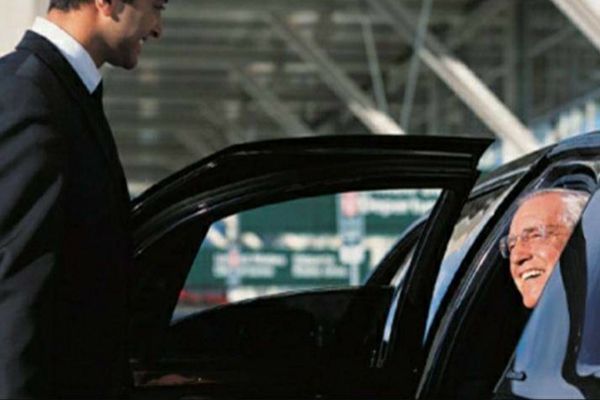 Smiling driver opening the door for an elderly passenger